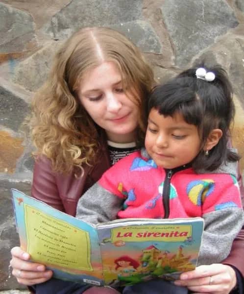 Freiwillige liest mit Kind, Ecuador