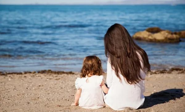 Au-Pair mit Gastkind am Strand
